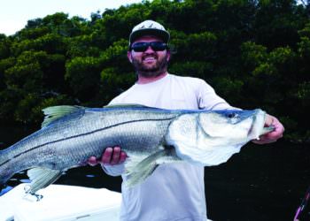 Fisherman shows off his snook catch Southwest Florida. Photo by Elizabeth Lempriere for Must Do Visitor Guides.