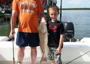 Young boy shows off his fresh catch caught on Wolfmouth Charters fishing trip Sarasota, FL