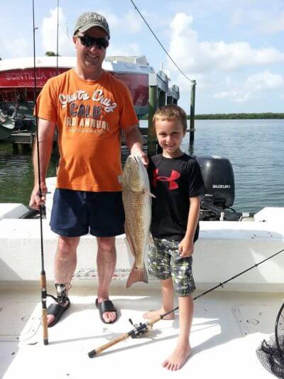 Young boy shows off his fresh catch caught on Wolfmouth Charters fishing trip Sarasota, FL
