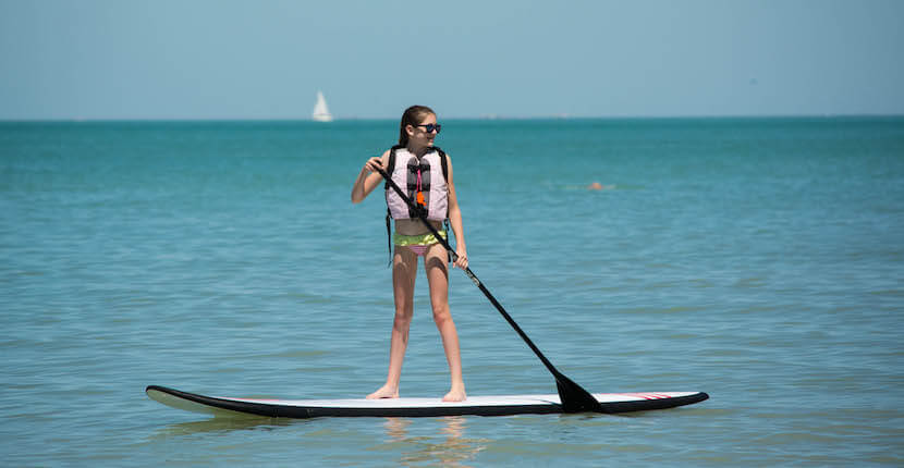 MustDo.com | Stand-up paddleboard, Vanderbilt Beach Park is a popular North Naples, Florida beach that has gorgeous powdery white sand and is close to area hotels, restaurants, and shopping. Photo by Debi Pittman Wilkey.
