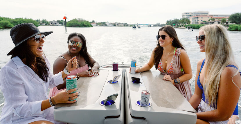 Four women sitting at a table on a boat on the water in Sarasota, Florida