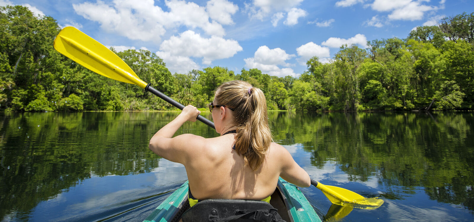 Woman kayaking along a beautiful tropical river with mangroves