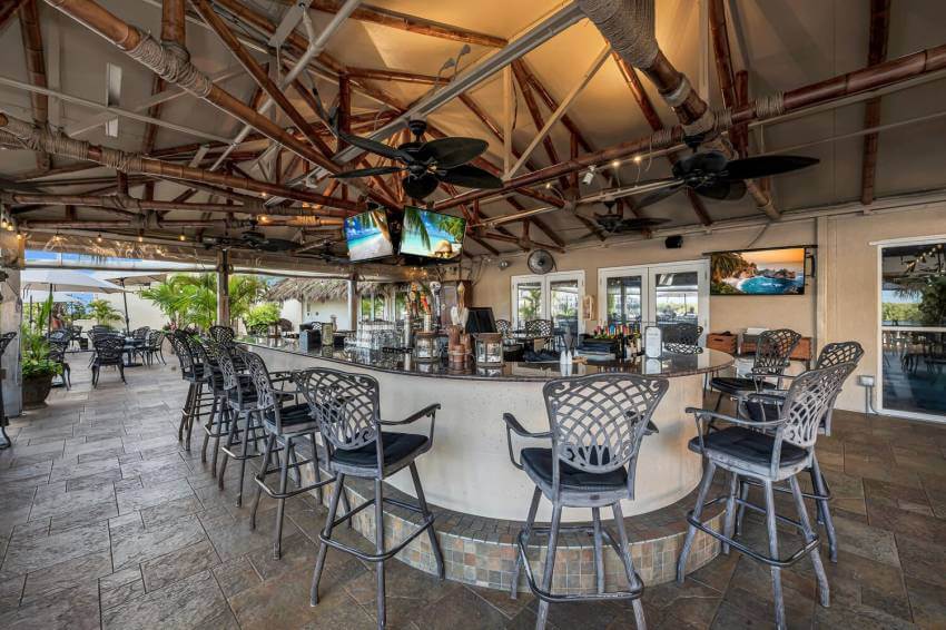 Covered outdoor patio and bar at Bambu Tropical Bar & Grille restaurant at Bayfront Inn Naples, Florida